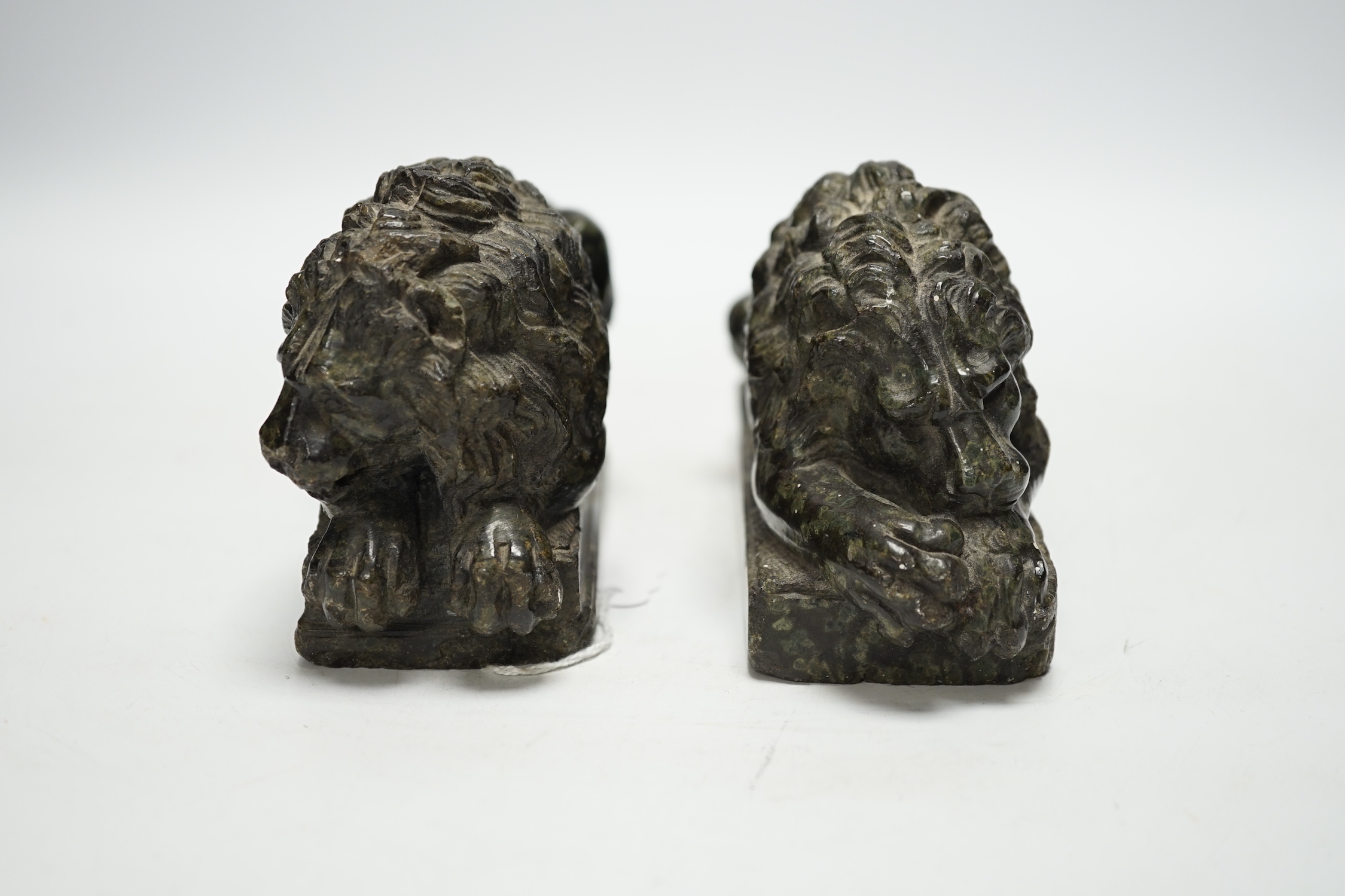 A pair of carved serpentine models of the Lucerne lions, 16cm wide